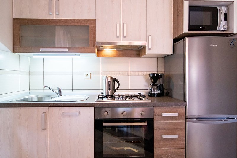 Moderne Küche mit Gasofen, Kochutensilien und elegantem Design.