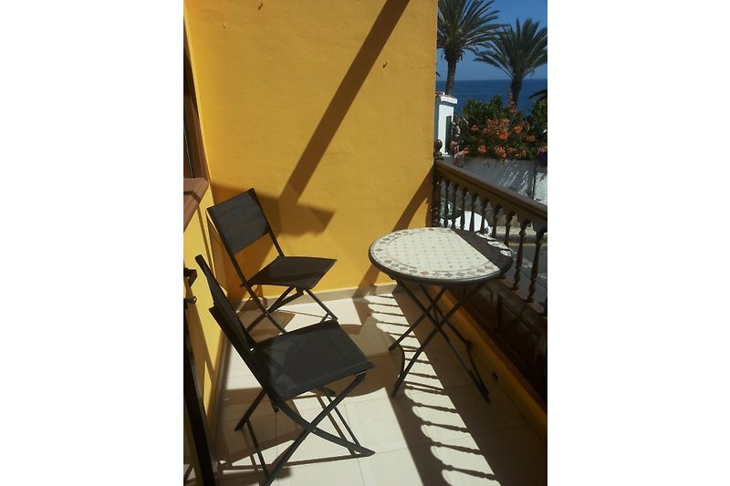 Terrasse mit Tisch/Stühlen/Sonnenschirm und Sonnenuntergang