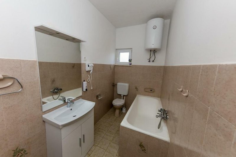 Modernes Badezimmer mit Spiegel, Waschbecken und Badewanne.