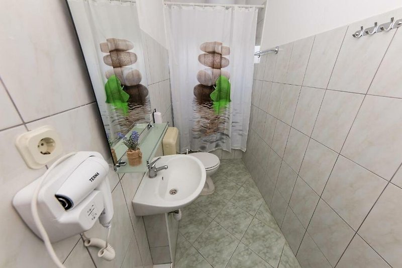Modernes Badezimmer mit lila Akzenten und Spiegel.