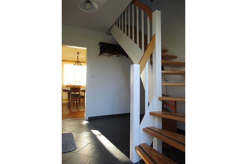 Gemütliches Holzinterieur mit schöner Treppe und Fensterblick.