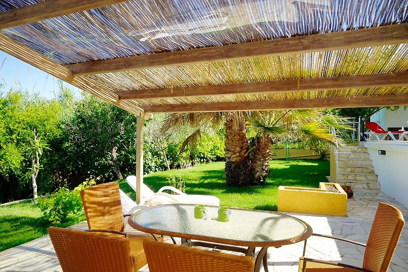 Liegewiese und große Terrasse neben dem Pool