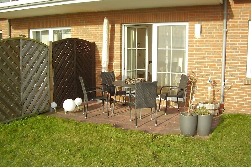 Einladende Terrasse mit bequemen Gartenmöbeln.
