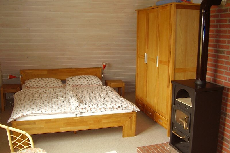 Schlafzimmer 2 oben mit Sitzcke, Flachbild-TV und Kaminofen