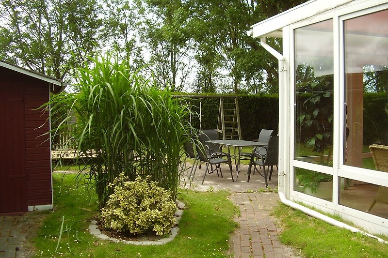 Einladender Garten mit grüner Rasenfläche und bequemen Möbeln.