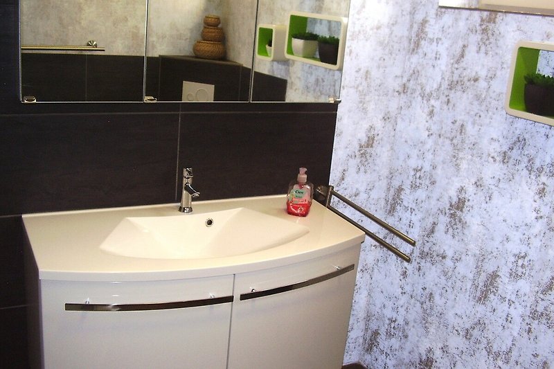 Modernes Badezimmer mit grosser flacher Dusche, Hänge-WC und Badmöbel.