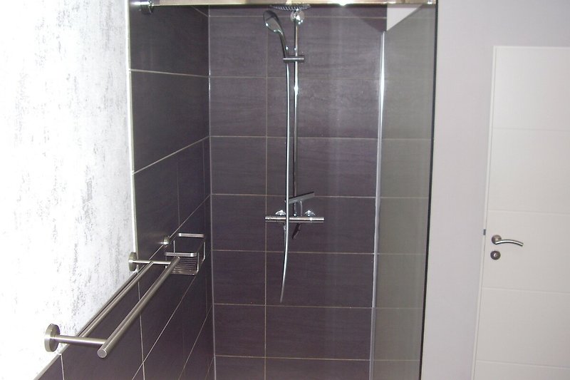 Modernes Badezimmer mit grosser flacher Dusche, Hänge-WC und Badmöbel.