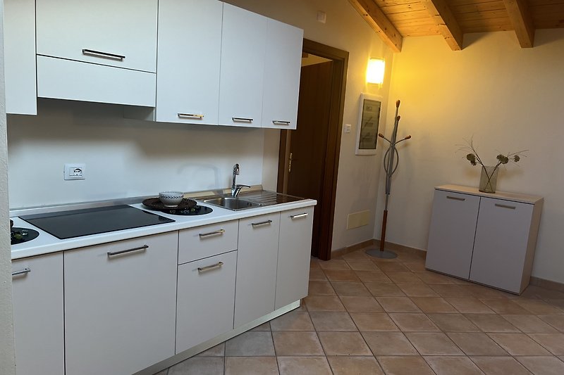 Moderne Küche mit Holzschrank, Küchenspüle, Arbeitsplatte und Gasherd.