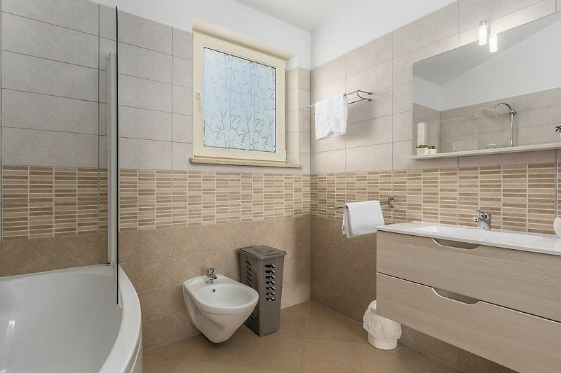 Modernes Badezimmer mit stilvoller Dusche und eleganter Badewanne.