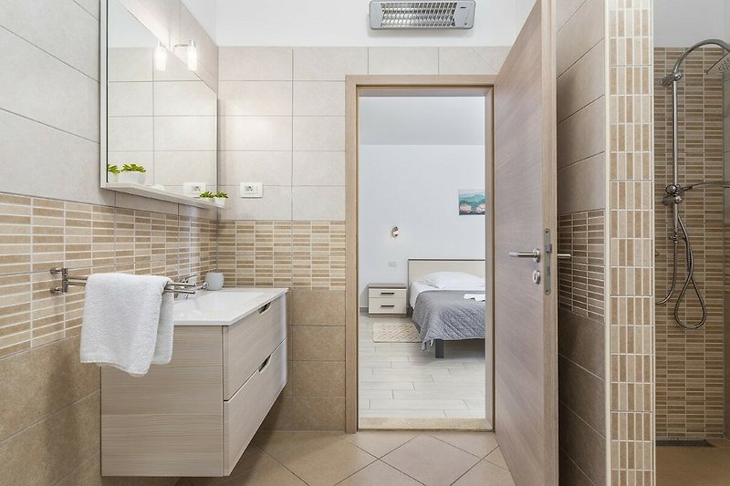 Modernes Badezimmer mit elegantem Design und Spiegel.