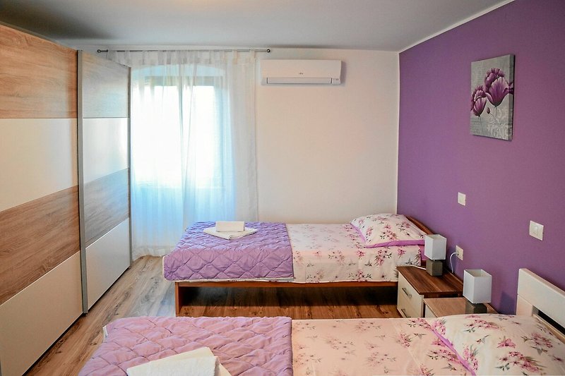 Rent this cozy bedroom with comfortable furniture, stylish lighting, and a beautiful purple bed frame.