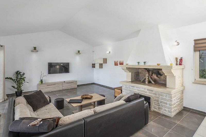 Stilvolles Wohnzimmer mit Pflanzen, Holztisch und gemütlicher Couch.