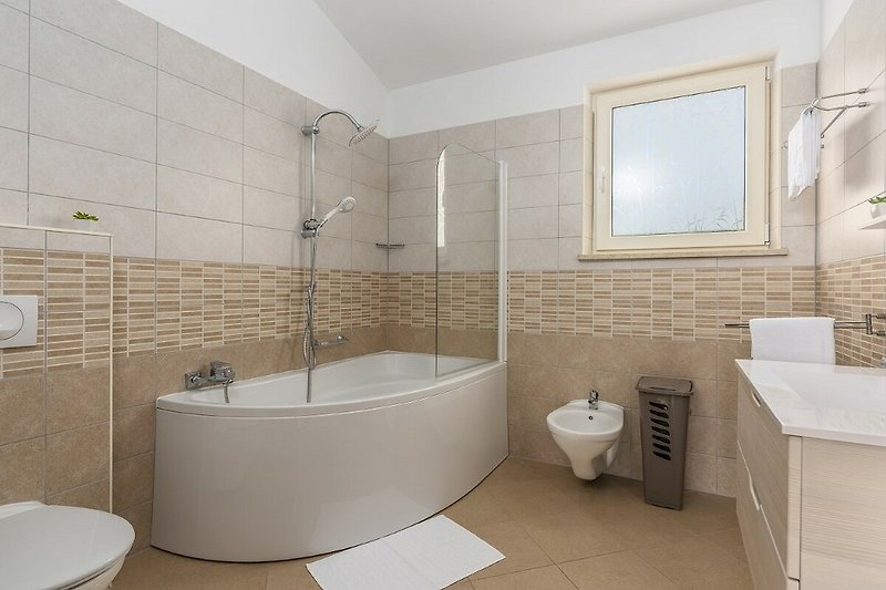 Modernes Badezimmer mit Dusche, Badewanne und elegantem Design.