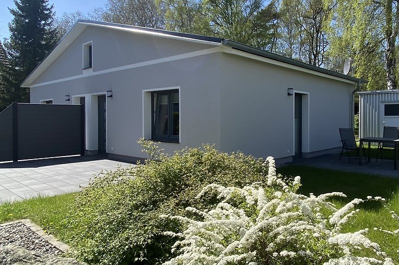 Gemütliches Haus mit Garten, Bäumen und einem einladenden Eingang.