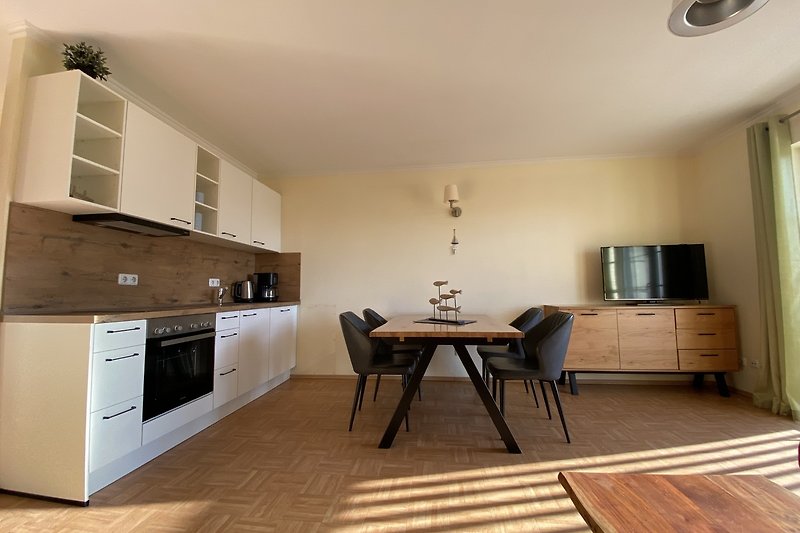 Küche mit modernen Möbeln, Holzakzenten und Fensterblick.