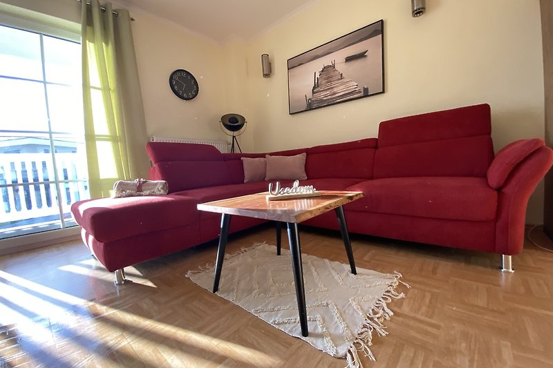 Wohnzimmer mit gemütlicher Couch, Holztisch und Dekoration.