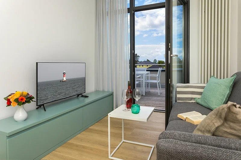 Wohnraum mit Sofa und klarer Linienführung und Blick auf die Dachterrasse