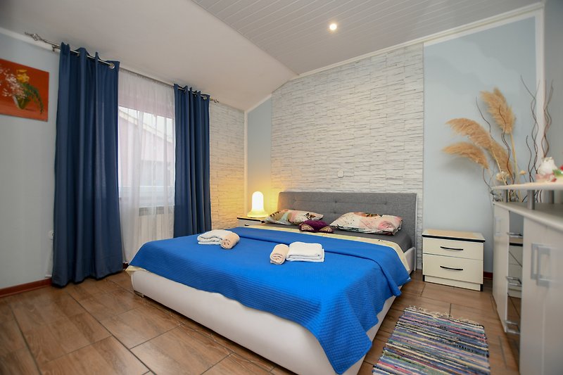 Gemütliches Schlafzimmer mit stilvoller Einrichtung und bequemem Bett mit bettwasche und handtucher