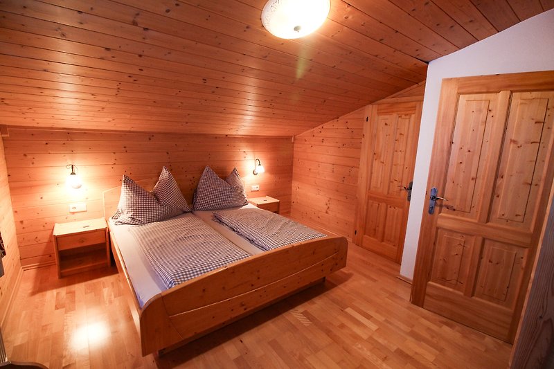 Geräumiges Schlafzimmer mit Holzbett und stilvollem Design.