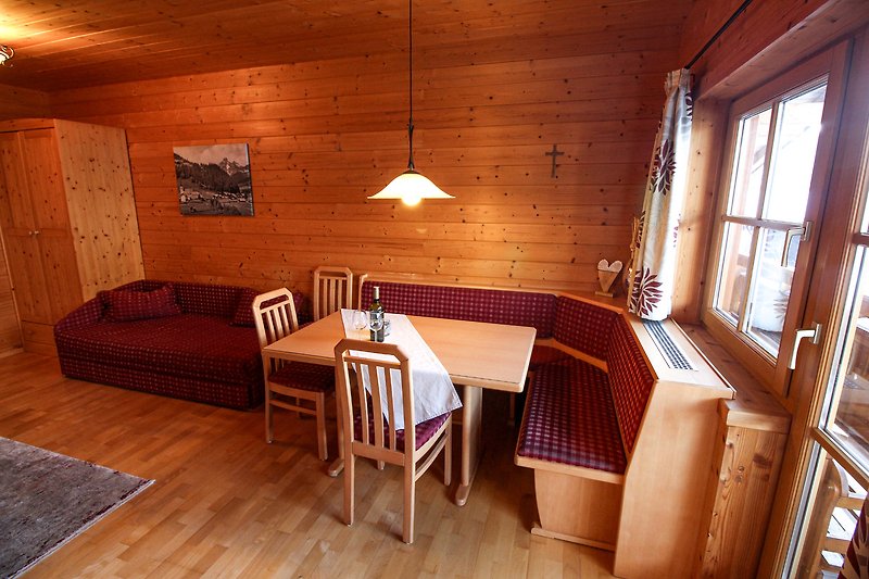 Einladendes Wohnzimmer mit Holzmöbeln und gemütlicher Beleuchtung.