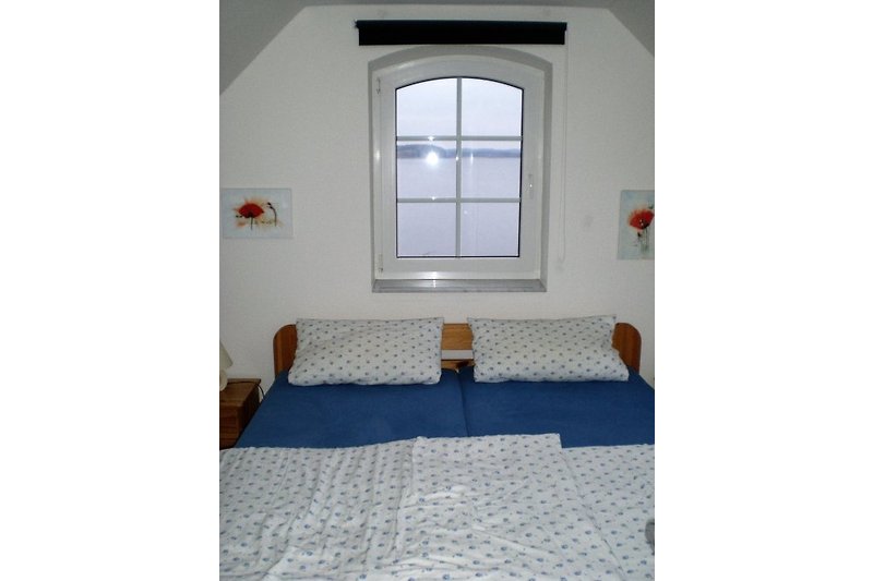 Schlafzimmer mit Doppelbett u. Blick auf den See