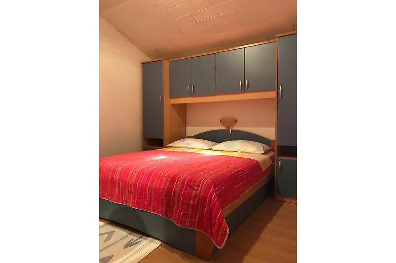 Modernes Schlafzimmer mit bequemem Bett und Holzmöbeln.