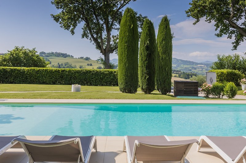 Una piscina con mobili da esterno e una vista panoramica mozzafiato.