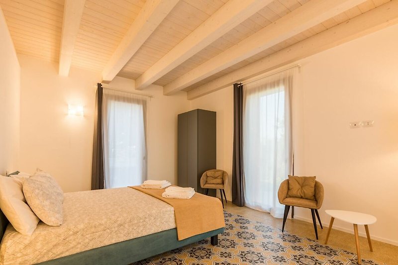 Una camera da letto confortevole con arredi in legno e una lampada a sospensione.