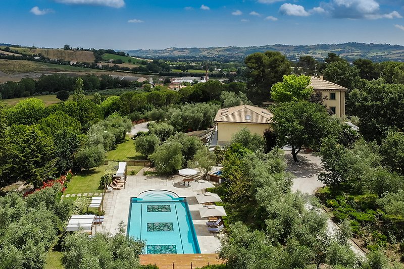 Vista dall'alto della villa con piscina e vista panoramica delle colline marchigiane