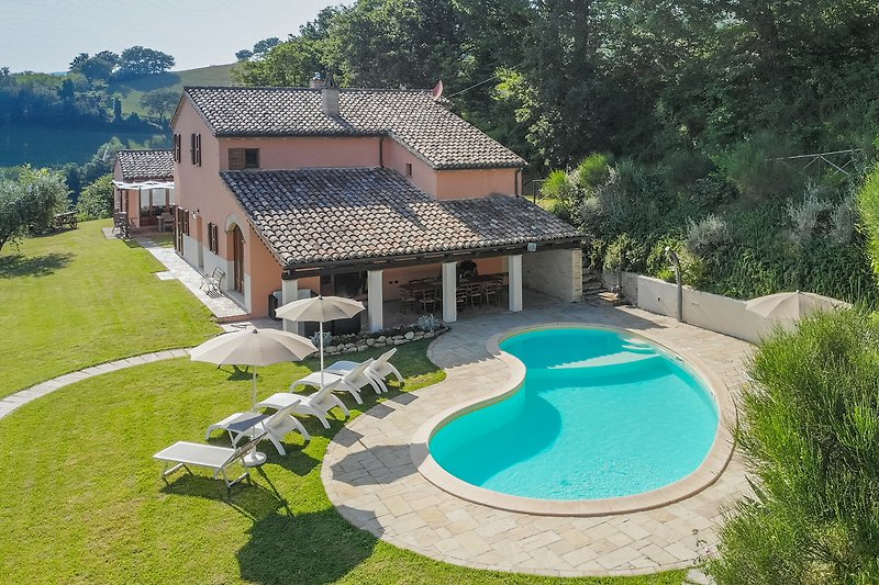 Una villa con piscina e giardino, circondata da una splendida vista panoramica.