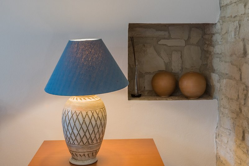 Un tavolo di legno con una lampada e un design d'interni artistico.