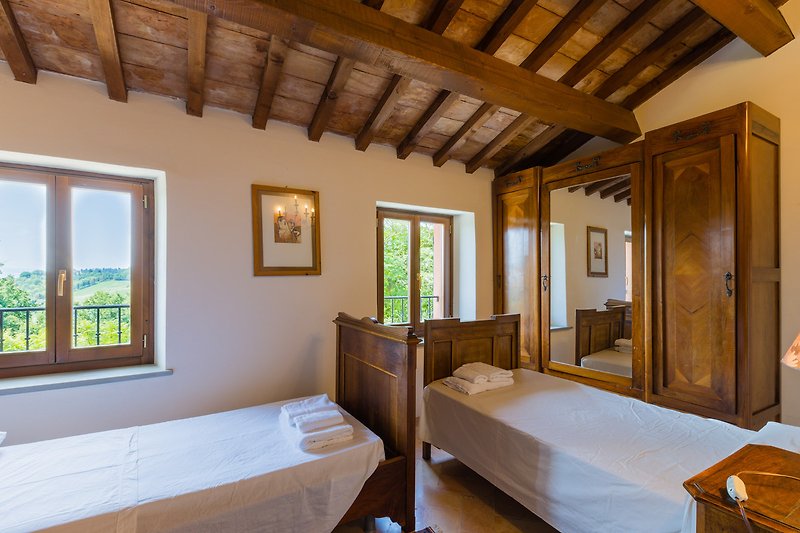 Una confortevole camera da letto con un letto in legno e un'ampia finestra.
