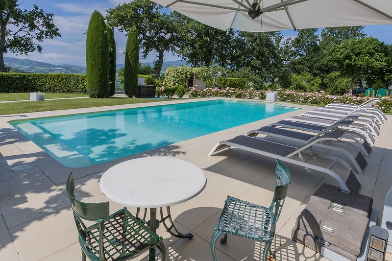 Una piscina con mobili da esterno e una vista panoramica mozzafiato.