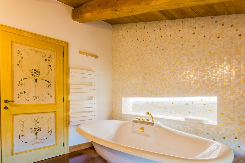 Una stanza da bagno con una vasca da bagno blu e un rubinetto in legno.