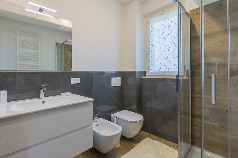 Una moderna stanza da bagno con lavabo, rubinetto e specchio.