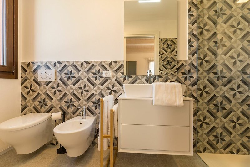 Una confortevole stanza da bagno con lavandino e rubinetto in ceramica.