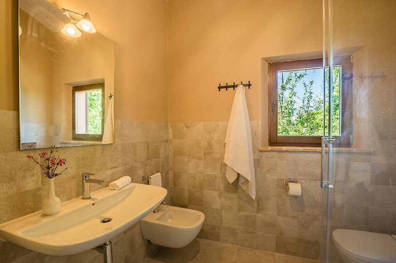 Una foto di un bagno moderno con doccia.