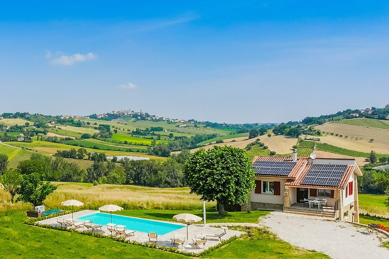 Questa immagine mostra una casa con un ampio giardino e una vista panoramica. Goditi una vacanza rilassante all'aria aperta!