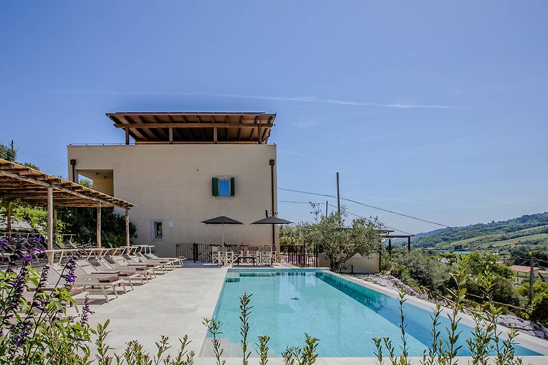 Villa mit Pool, Balkon und Outdoor-Möbeln im Resort.