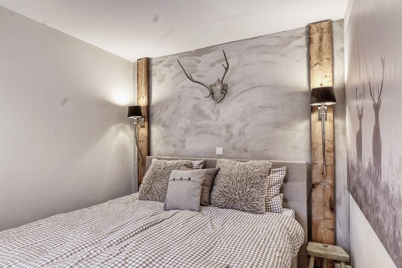 Elegantes Schlafzimmer mit Holzbett, Lampenschirm und Kunst.