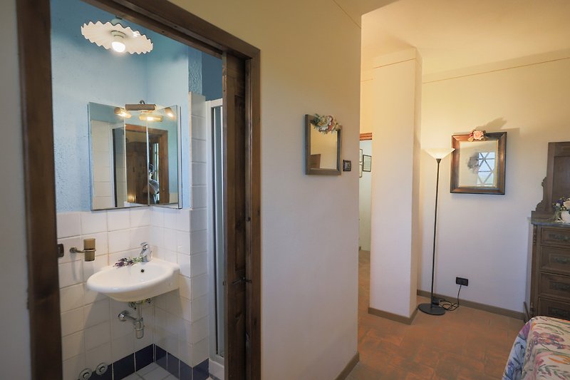 Una sala de baño con un elegante espejo, marco de foto y grifo.
