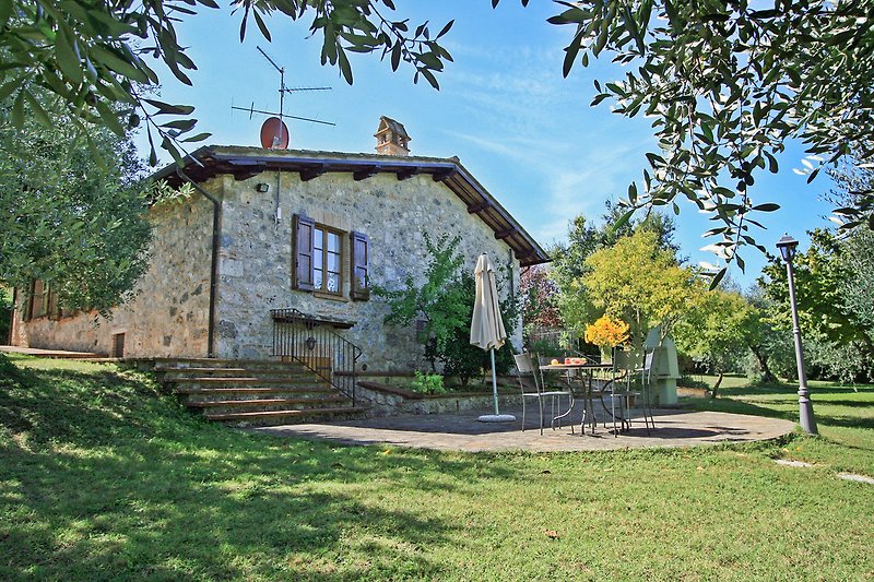 Una casa di campagna con un giardino verde e una vista panoramica.