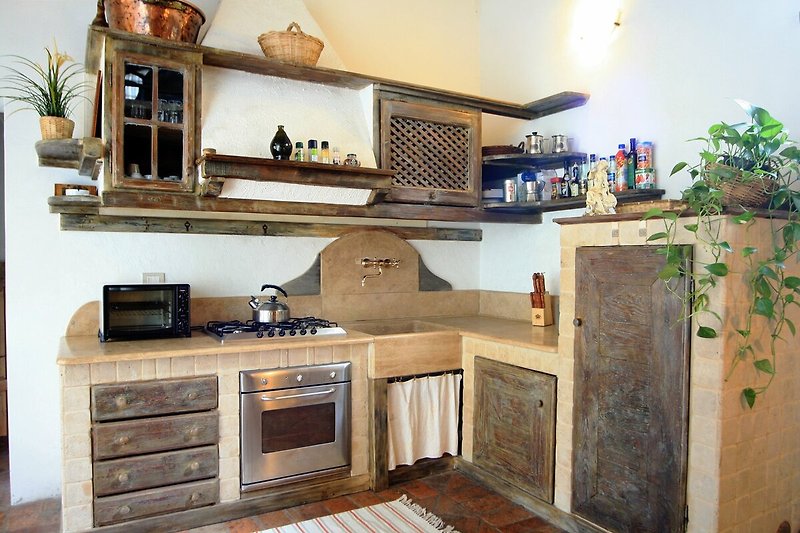 Una cucina moderna con elettrodomestici in acciaio e un piano in legno.