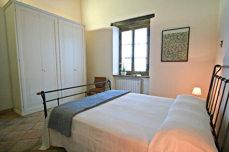 Una camera da letto con arredamento in legno e una lampada.