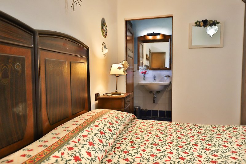 Una camera da letto con un comodo letto, arredamento in legno e una lampada a soffitto.