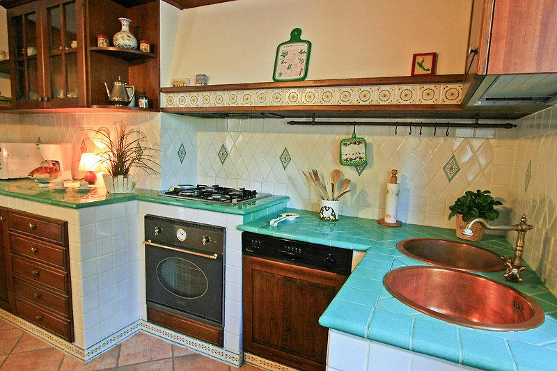 Una cucina con mobili in legno, lavello e illuminazione.