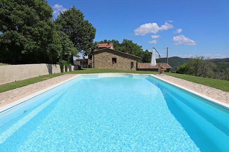 Una piscina con vista panoramica, circondata da un paesaggio naturale.