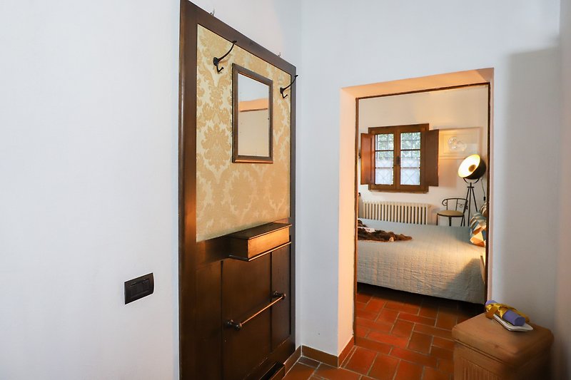 Una casa con un elegante specchio, una porta di legno e un lampadario.