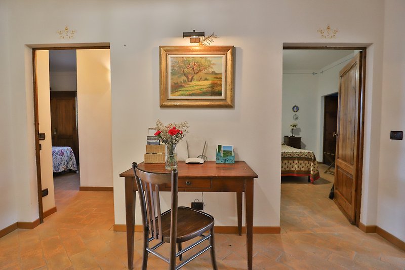 Un elegante salotto con mobili di legno e un quadro floreale.