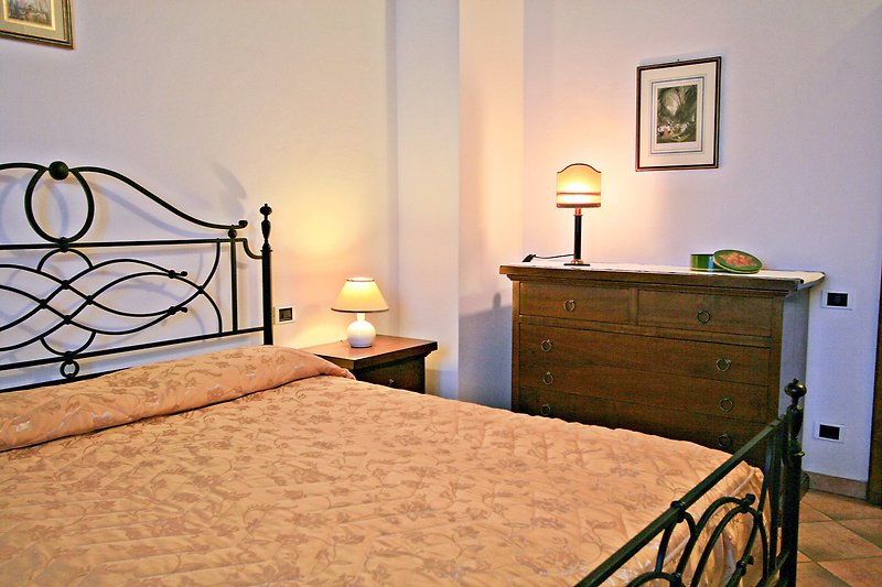Una camera da letto con un comodo letto, armadio e lampada.